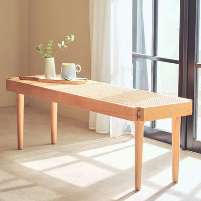 Wooden coffee table with a cup and vase in a bright room with large windows.