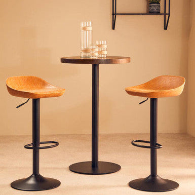 Two wooden bar stools with black metal bases in front of a small round table against a beige wall.