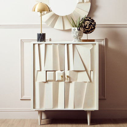 Decorative cabinet with abstract design, round mirror, and plants against a light wall.