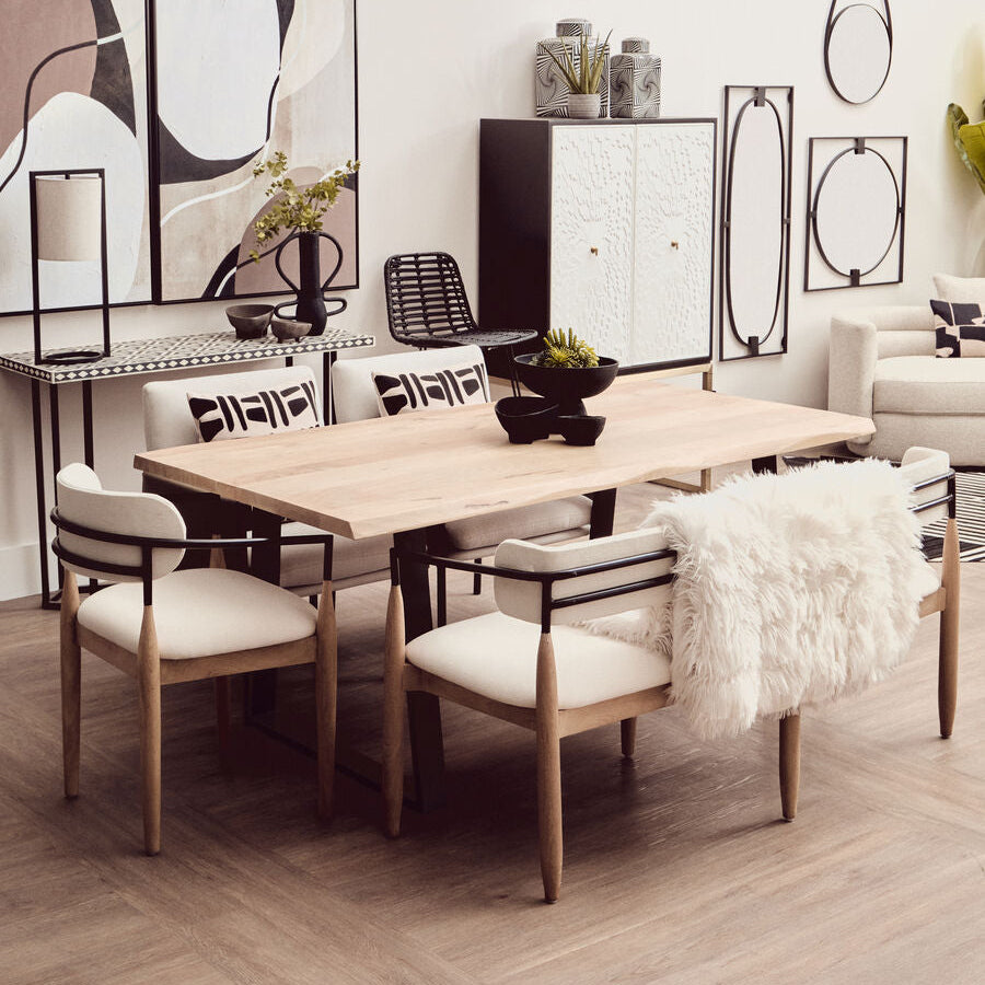 Dining room with wooden table and chairs, abstract art on the wall, and decorative elements.