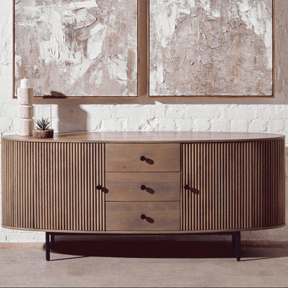 Wooden sideboard with abstract art on a white brick wall