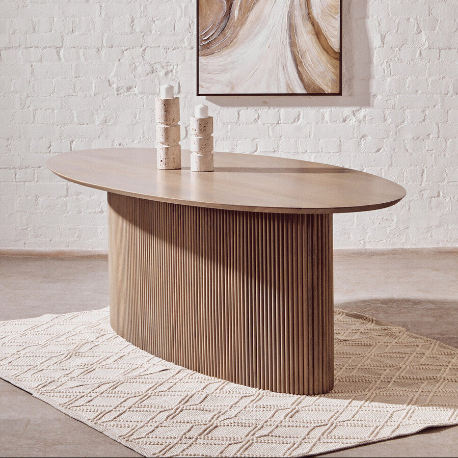 Wooden dining table with abstract art on the wall in a room.