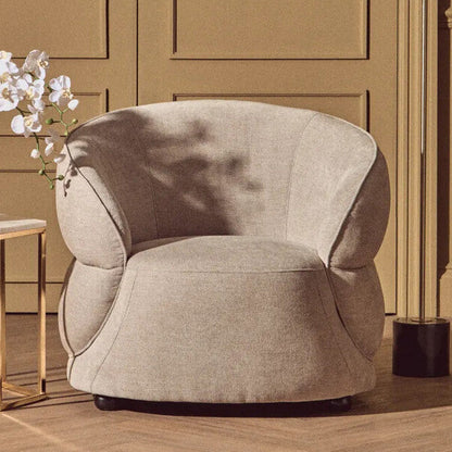Modern beige armchair in a room with wooden flooring and panelled walls.