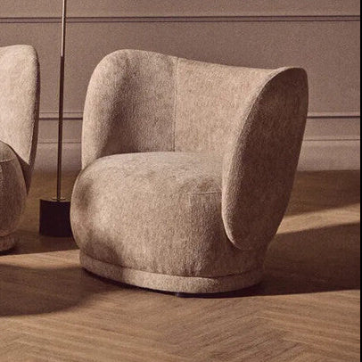 Modern living room with beige sofa, armchair, and side table against a neutral wall.