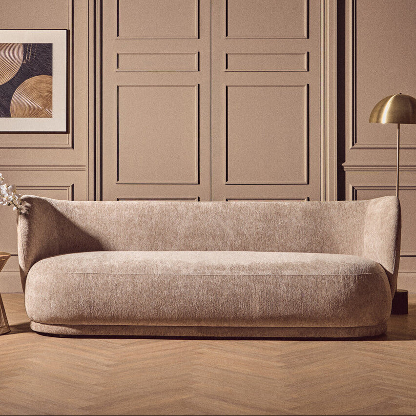 Beige sofa in a room with beige walls and wooden floor.