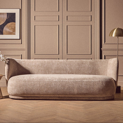 Beige sofa in a room with beige walls and wooden floor.