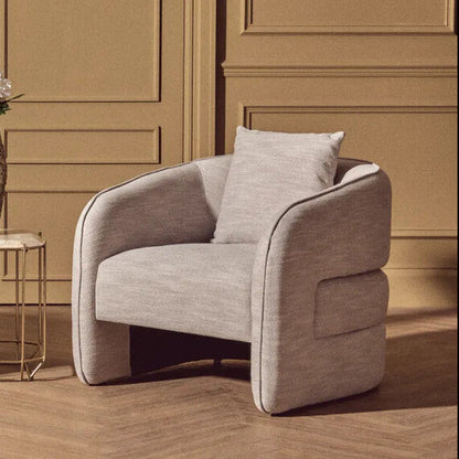 Two modern armchairs in a room with a vase and flowers on a small table.