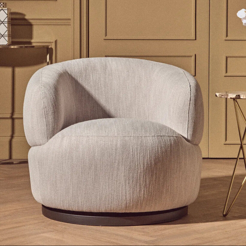 Modern beige armchair in a stylish room with decor elements.