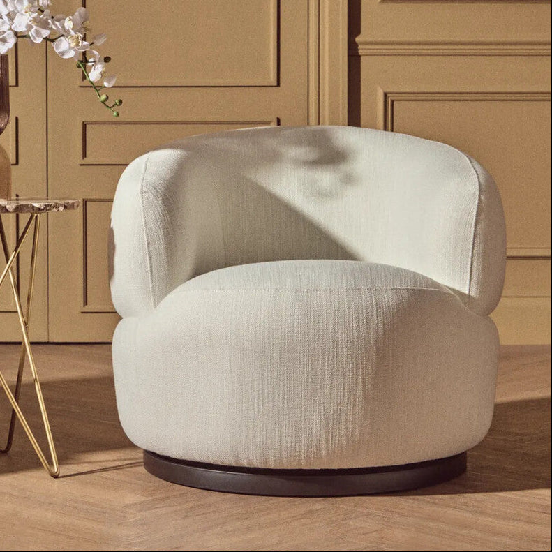 Beige armchair in a room with wooden paneling and a small table with a vase.