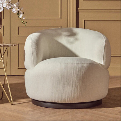 Beige armchair in a room with wooden paneling and a small table with a vase.