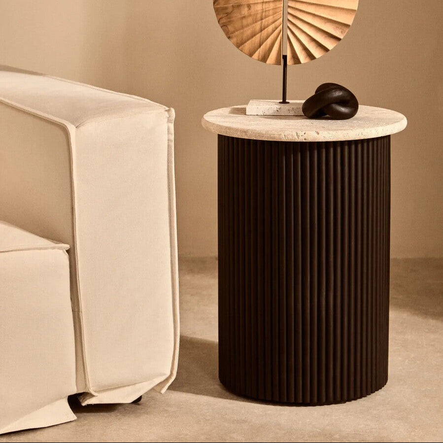 Modern side table with decorative items against a beige wall