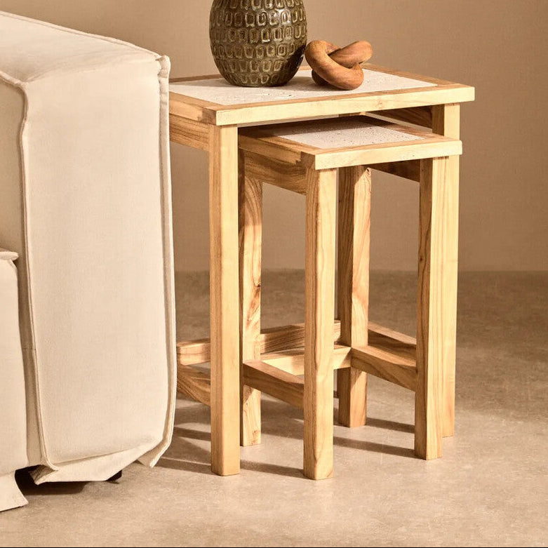 Wooden side table with a textured vase and plant in a living room setting.