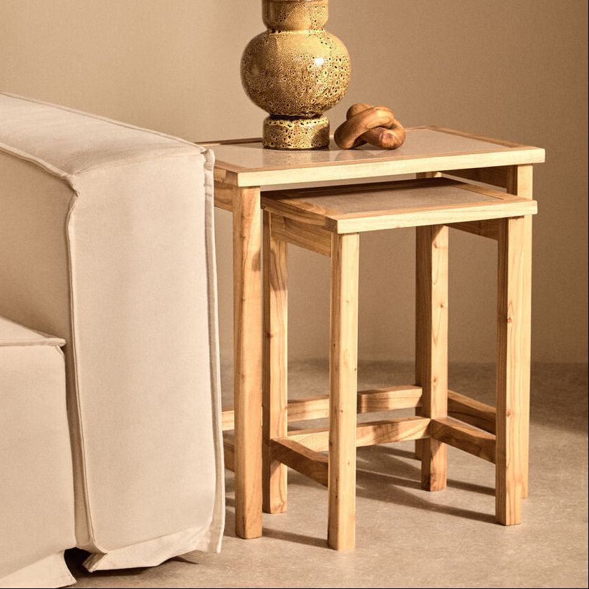 Wooden side table with a vase and decorative item next to a beige armchair.
