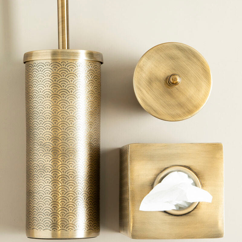 Brass-patterned toilet brush holder, tissue box cover, and tissue on a beige background