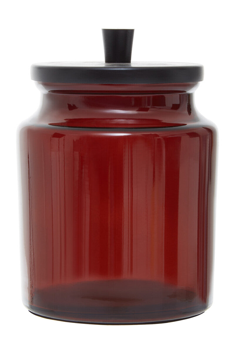 Red glass jar with a black lid on a white background