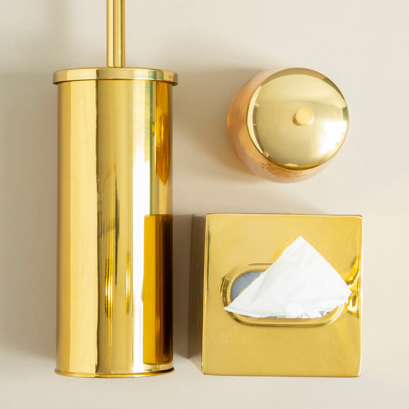 Gold toilet brush holder, tissue box cover, and toilet seat cover on a beige background
