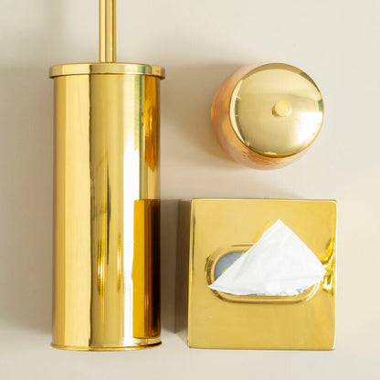 Gold toilet brush holder, tissue box cover, and toilet seat cover on a beige background