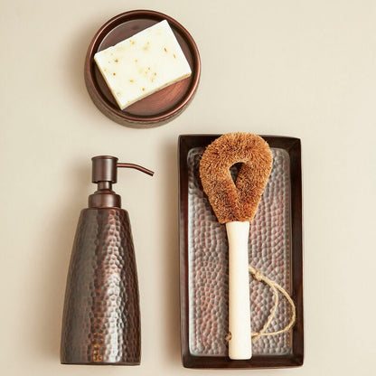 Set of cleaning tools including a soap dispenser, sponge, and scrubber on a neutral background