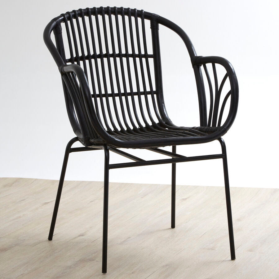 Black wicker chair on a light wooden floor with a white background