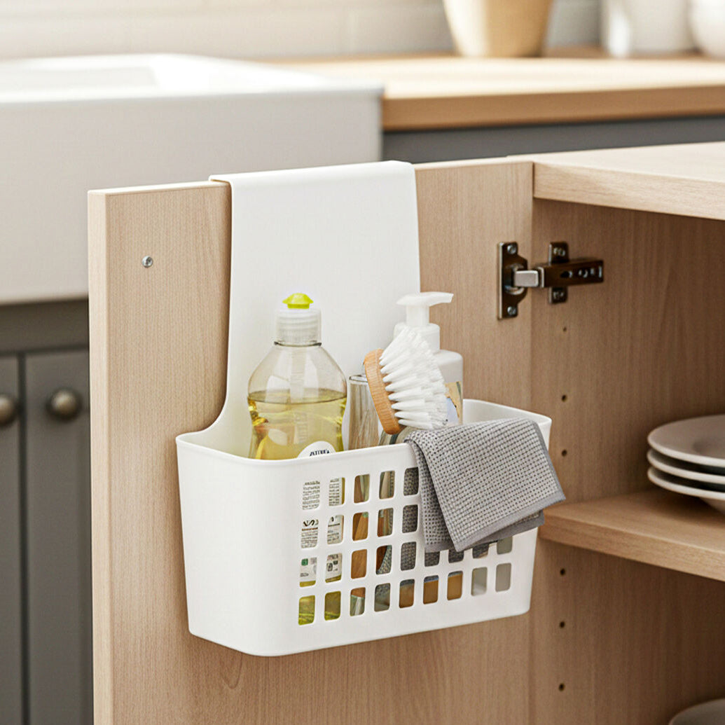 White storage basket hanging on a wooden cabinet door with kitchen items inside, labeled &