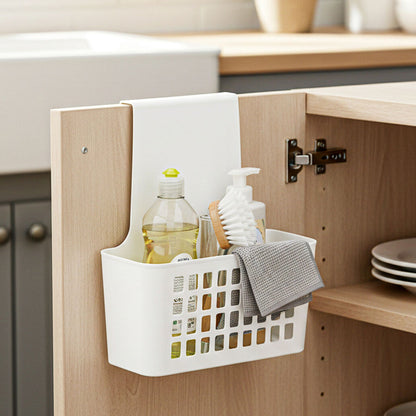 White storage basket hanging on a wooden cabinet door with kitchen items inside, labeled &
