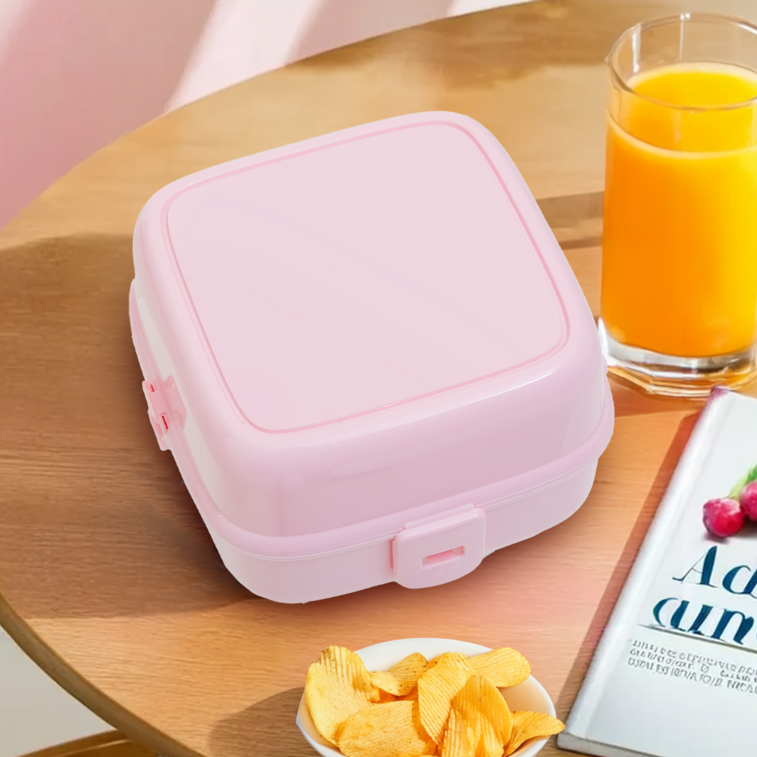 Pink lunch box on a table with snacks and juice