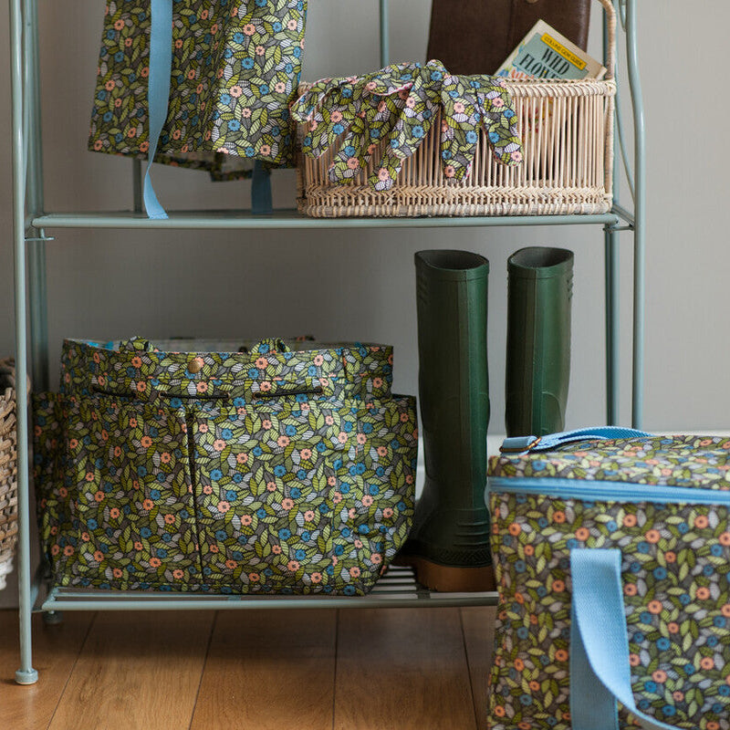 Floral-patterned bags and baskets on a metal shelf against a neutral wall.