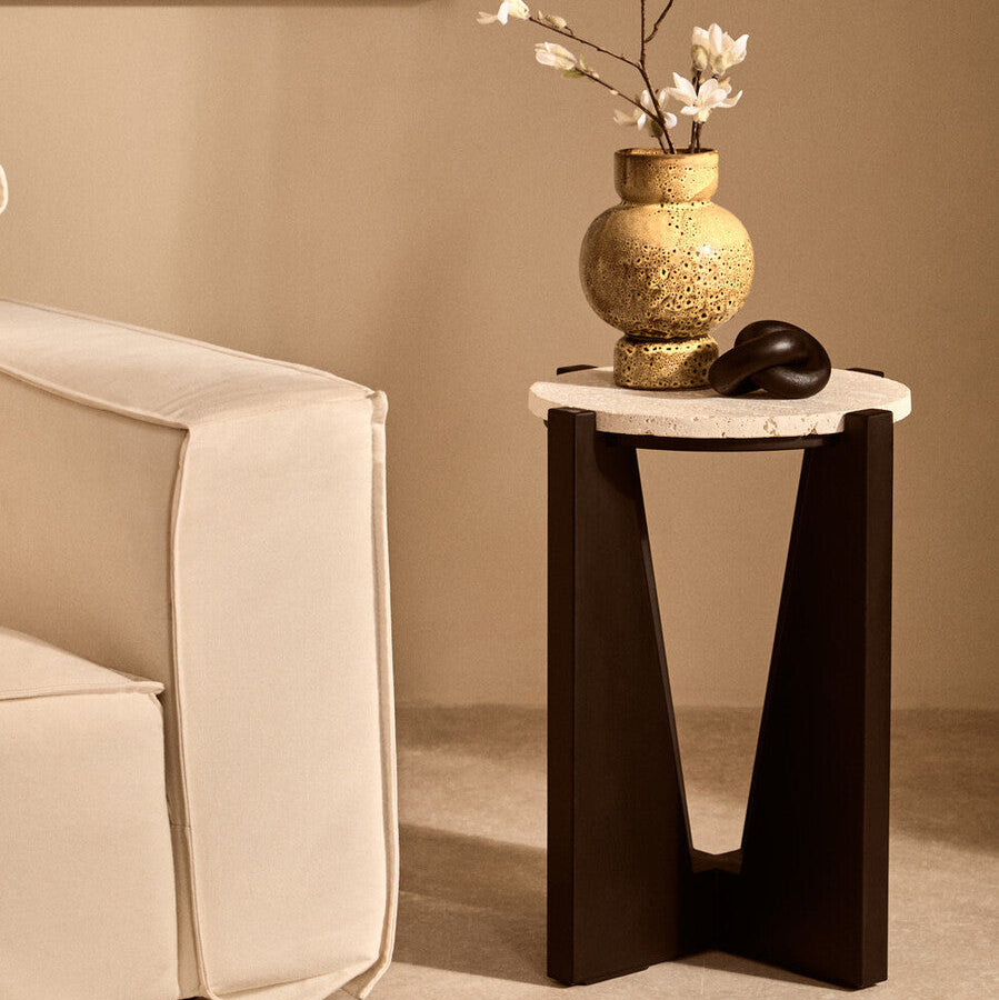 Small side table with decorative vase and flowers in a living room setting.