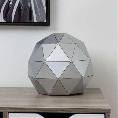 Geometrically patterned decorative object on a wooden shelf with a white drawer.
