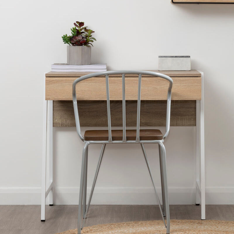 Wooden desk with metal chair against a white wall