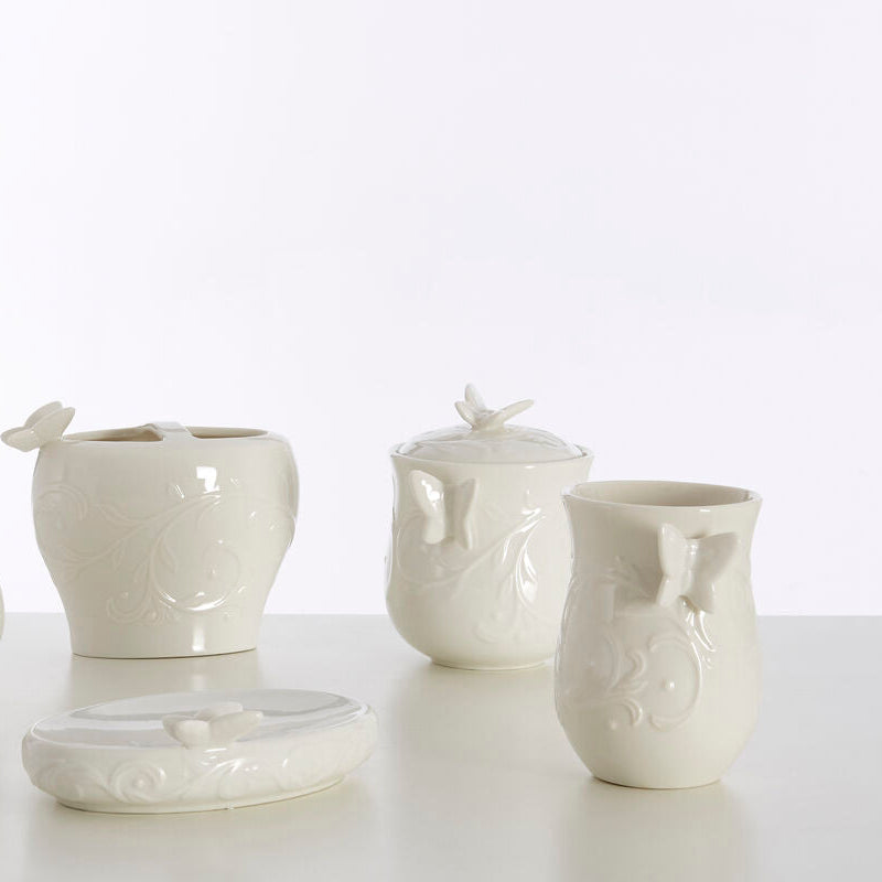 Set of white ceramic bathroom accessories on a light background