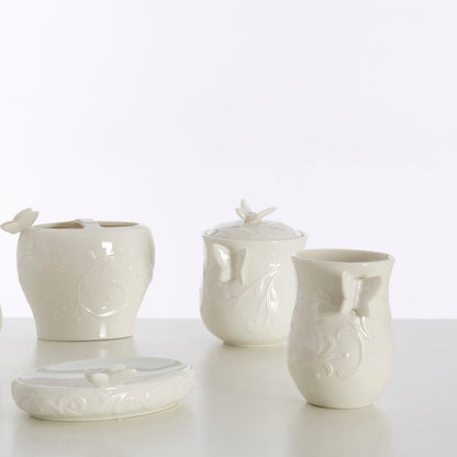 Set of white ceramic bathroom accessories on a light background