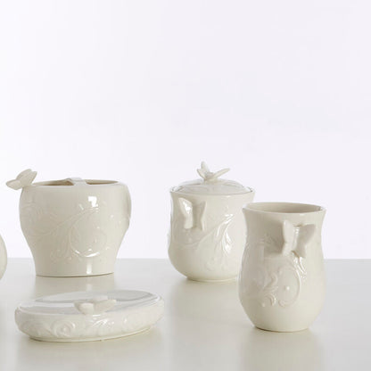 Set of white ceramic bathroom accessories on a light background