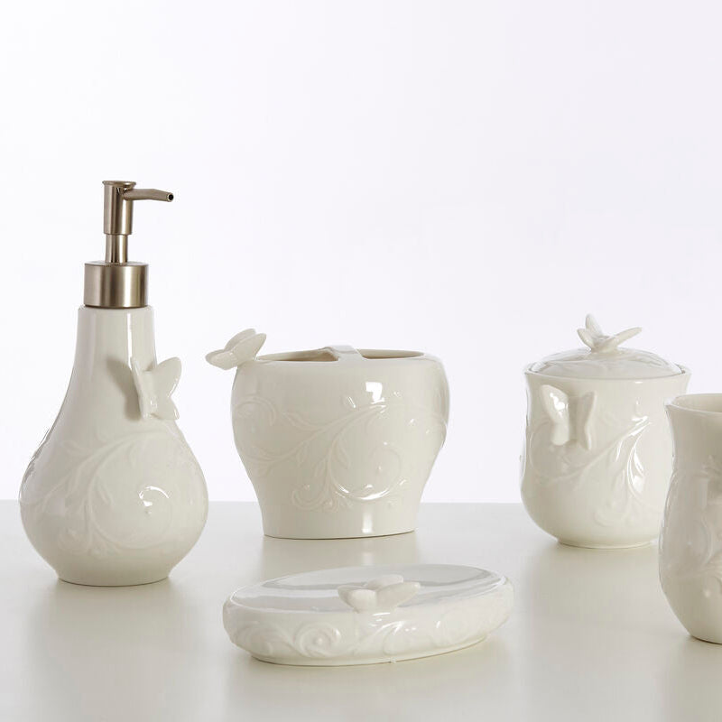 Set of white ceramic bathroom accessories on a light background