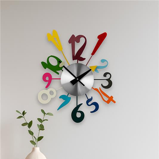 Colorful wall clock on a light gray wall with a wooden table and decorative items.