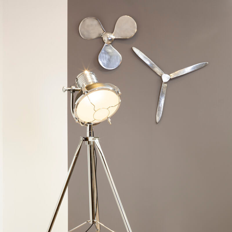 Floor lamp with propeller design on a wooden floor against a gray wall