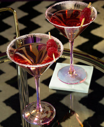 Two red cocktails in martini glasses with a checkered tablecloth background