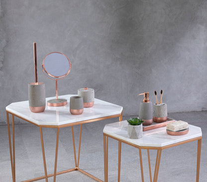 Decorative items on marble tables against a gray concrete wall