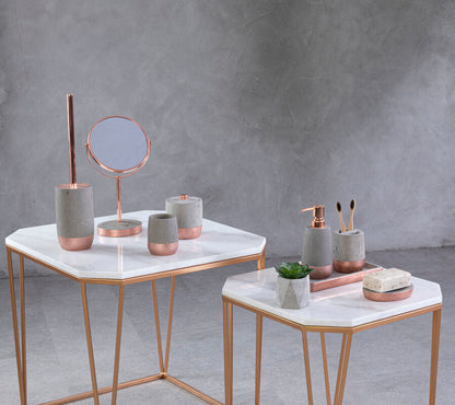 Decorative items on marble tables against a gray concrete wall