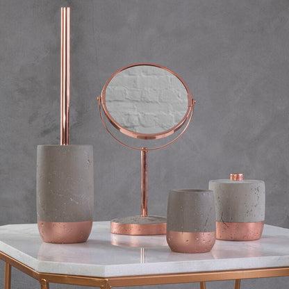 Decorative items including a mirror, candles, and a brush holder on a marble surface with a gray background.